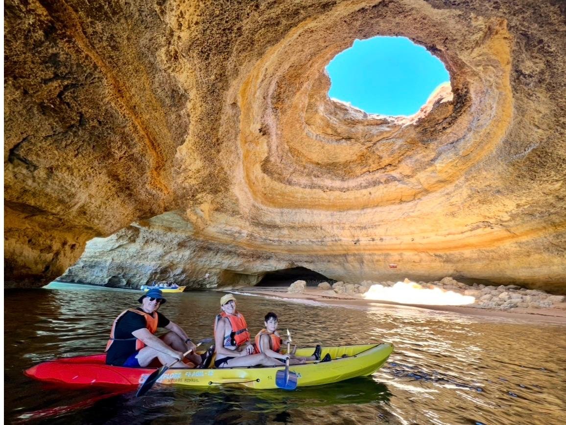 Family kayaking inside a beautiful coastal cave